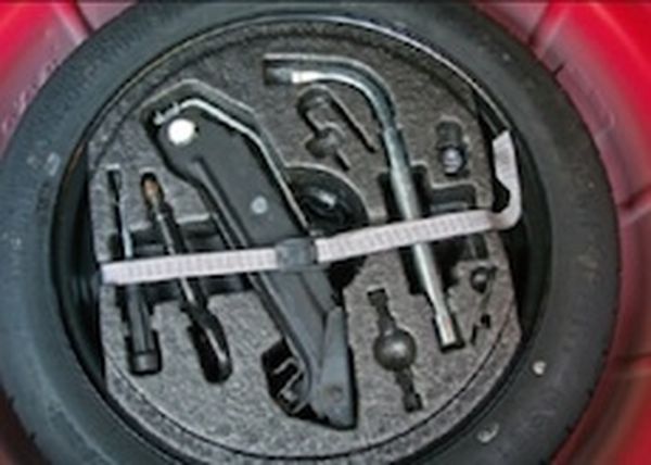 Car jack, wheel brace, and spare tyre stored together